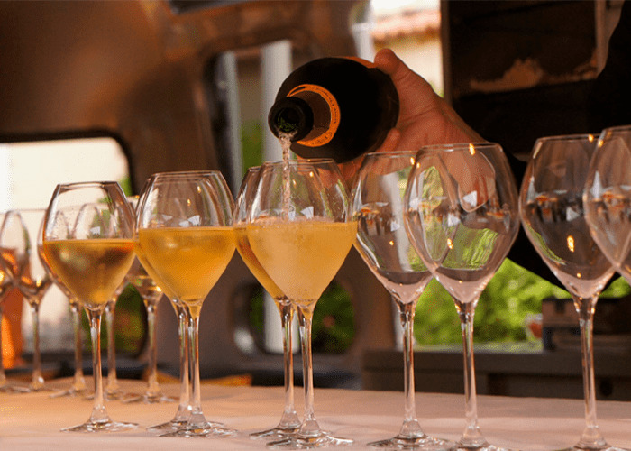 Pessoa enchendo taças com vinho espumante