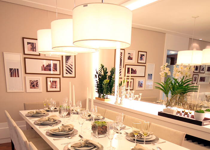 Mesa de jantar posta, retangular grande branca. com três pendentes sobre ela