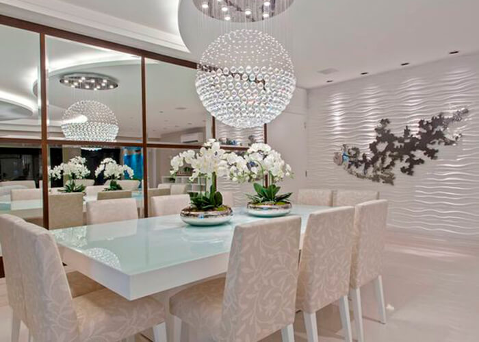 Sala de jantar branca com lustre acima da mesa