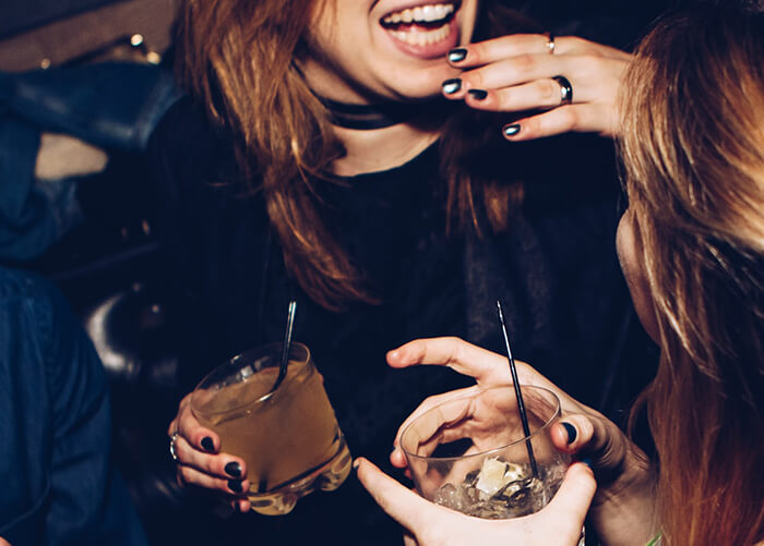mulher sorrindo segurando um drink