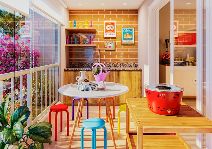 varanda gourmet, com mesa redonda e banquinhos coloridos, ao fundo pia. Parede de tijolinho com quadros coloridos no estilo do ambiente