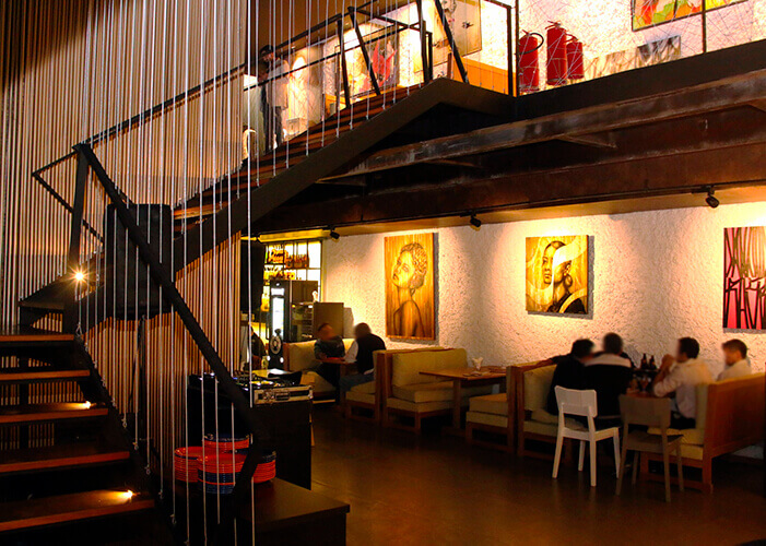 Ambiente interno de bar com escada em L.