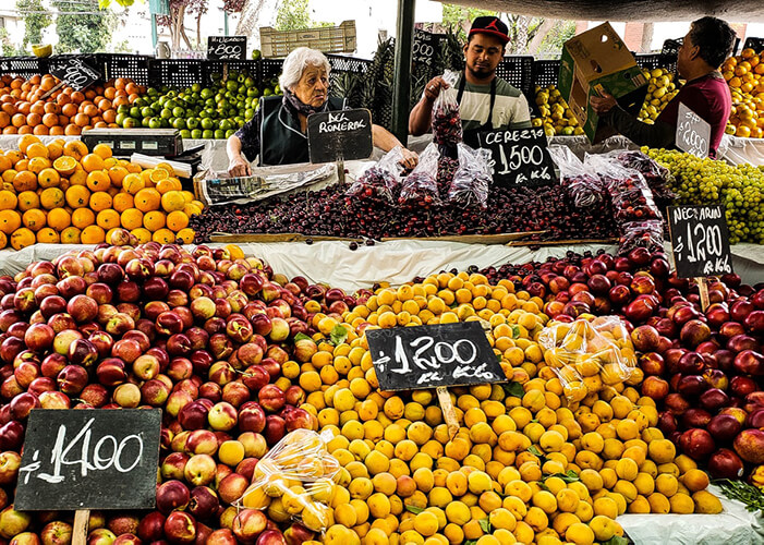 banca de frutas com placas de preços.