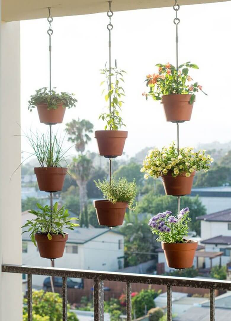 vasos de flor e temperos pendurados na varanda do apartamento