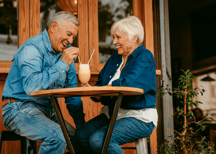 homem e mulher idosos felizes tomando suco