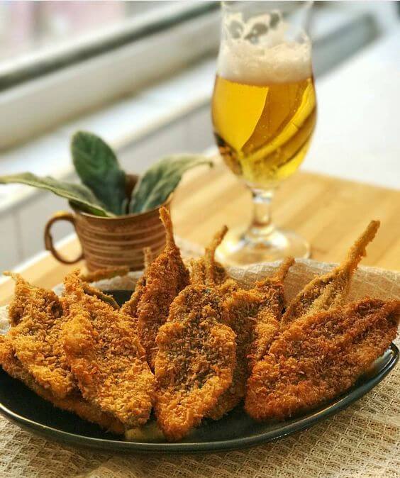 prato da planta peixinho frita, acompanhada com uma taça de cerveja