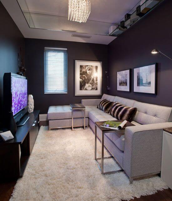 sala de estar com paredes roxa escura, teto claro e tapete grande branco