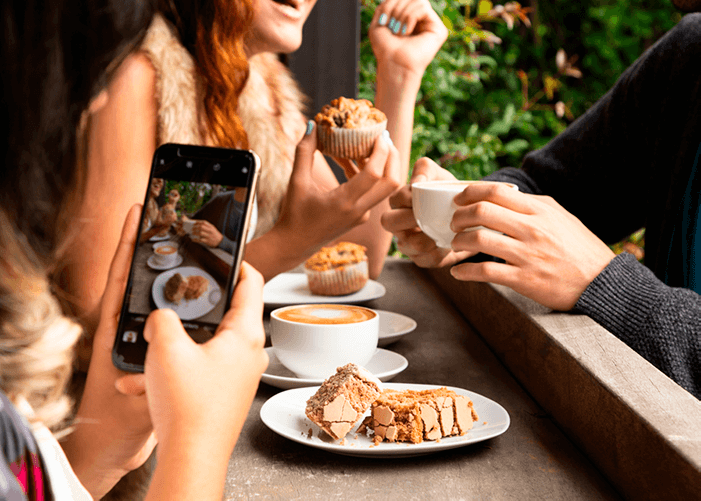 Pessoa fotografando vários pratos de comida