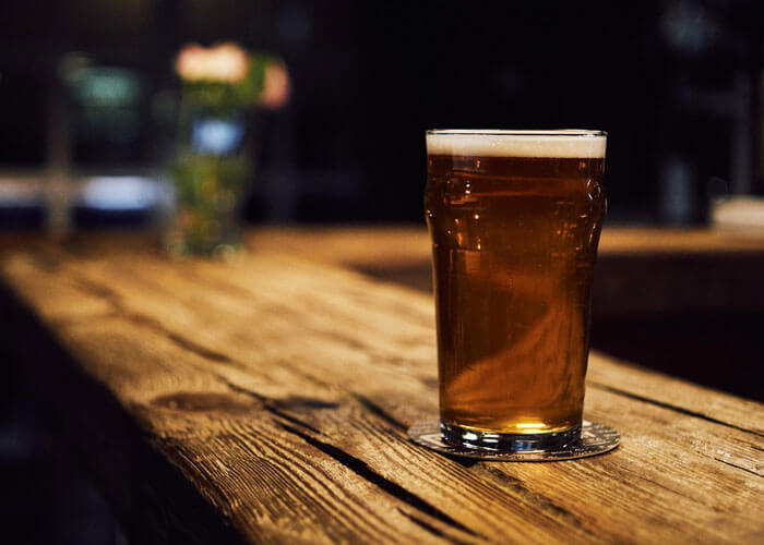 copo-de-cerveja-sobre-balcão-de-madeira