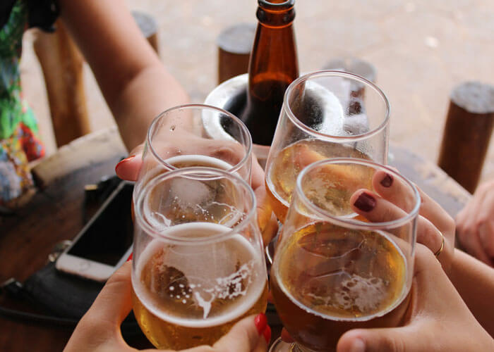 mãos-de-mulheres-brindando-com-cerveja